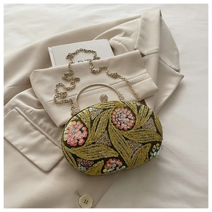 Detalle de bolso de noche vintage con bordados dorados y lentejuelas rosas brillantes