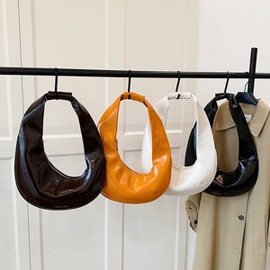 Sacs hobo brillants en quatre couleurs présentés sur un support métallique minimaliste