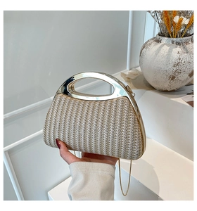 Détail d'un sac à main en paille tressée avec poignée métallique et bandoulière