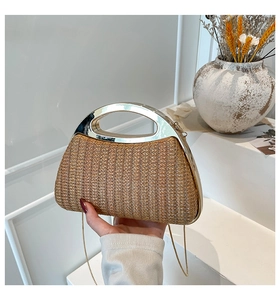Détail du sac à main en paille tressée avec anse argentée et chaîne dorée