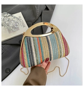 Détail d'un sac à main tissé coloré avec poignées métalliques dorées et bandoulière chaîne