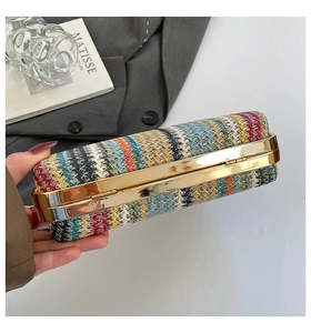 Détail d'une pochette bohème tissée en paille colorée avec un cadre en métal doré