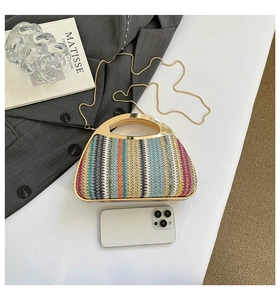 Détail d'un sac à main tissé coloré avec poignée métallique dorée et bandoulière