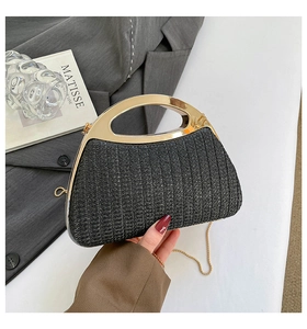 Détail de pochette de soirée tissée noire avec poignée évidée dorée et bandoulière