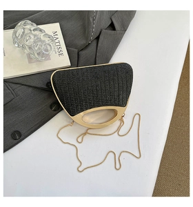 Détail de la texture tressée noire et de la poignée en métal doré d'un sac à main chic
