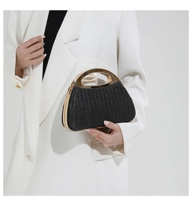 Détail du sac tressé noir avec poignée en métal doré élégante et texture luxueuse