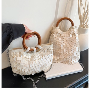 Detailansicht der weißen Muschel-Pailletten und Holzgriffe an eleganten Abendtaschen