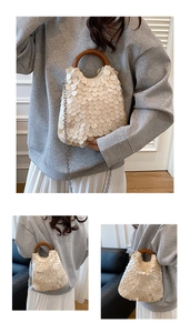 Detailansicht der beigen Muschel-Handtasche mit braunem Griff und silbernem Kettenriemen