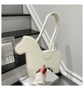 Detail of unique horse-shaped cream PU leather shoulder bag on modern minimalist steps
