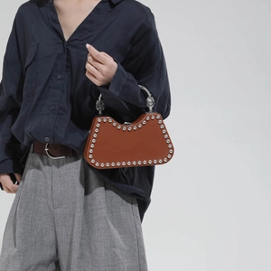 Sac boîte tendance marron rouge avec clous argentés et poignée en métal en studio