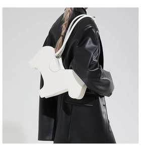 Detail of creative puppy shaped shoulder bag in white PU leather worn by a model