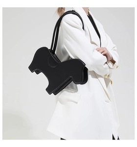 Detailed view of black zebra-shaped PU leather shoulder bag on a white suit model