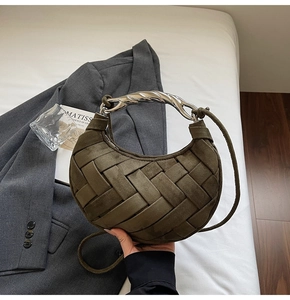 Detail of olive green woven crescent bag with textured silver metal handle and suede finish