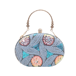 Bolso de noche azul con lentejuelas, bordado floral y asa dorada para eventos de gala