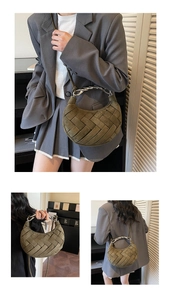 Detail of olive green woven crescent bag with textured finish and silver chain handle