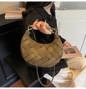 Detail of woven suede crescent bag with silver horsebit buckle and slim shoulder strap