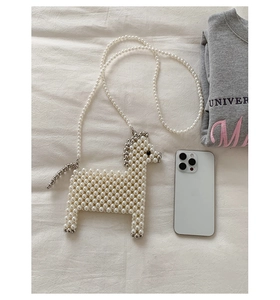 Detail of horse-shaped pearl woven bag with silver bead accents and long crossbody chain