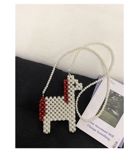 Detailed close-up of a handmade white pearl beaded horse bag with red bead accents