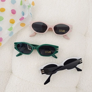 Detailed view of three vintage oval sunglasses with UV400 protection labels on soft fabric