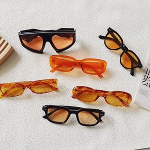 Occhiali da sole cat eye e rettangolari arancioni con montature nere e color ambra