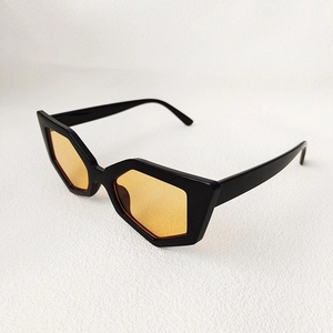 Detailed side view of polygon cat-eye sunglasses with thick black frame and orange lenses