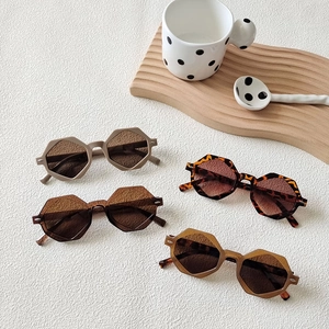 Flat lay of geometric octagonal sunglasses in leopard, beige, and brown color tones