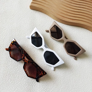 Three geometric cat-eye sunglasses in tortoiseshell, white and matte nude on white background