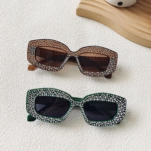 Detail showing oversized square frames with rhinestone embellishments on sunglasses