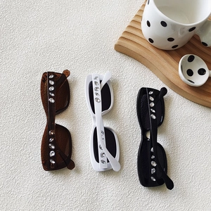 Fashionable oval sunglasses with rhinestone accents in black, white, and brown colors
