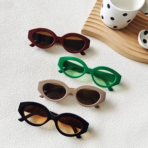 Retro oval cat-eye sunglasses with thick resin frames in red, green, beige, and black