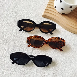 Retro cat eye sunglasses set with leopard and black frames on a textured white surface