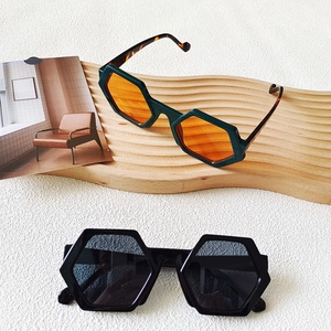 Detail of oversized hexagonal sunglasses in tortoiseshell green and classic black frames