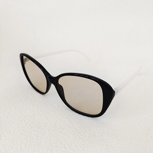 Detail of oversized sunglasses with black front frame and contrasting white temples