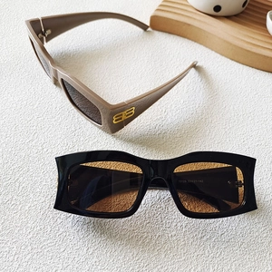 Détail de lunettes de soleil rectangulaires avec un logo BB doré en métal sur la branche
