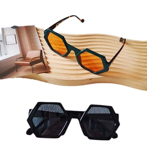 Oversized hexagonal sunglasses in black and green tortoiseshell frames with orange lenses