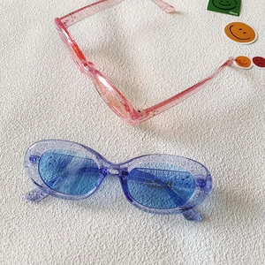 Detail der Glitzer-Ovalshennenbrille mit UV400-Schutz und CE-Zertifizierungsschildern