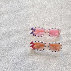 Close-up of pearl and rhinestone embellished girl's sunglasses with cute bow accents