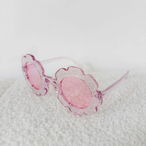Macro detail of kids pink flower sunglasses with glitter frame and tinted lenses