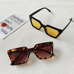 Details von quadratischen Retro-Sonnenbrillen in Schildpatt und Schwarz mit gelben Gläsern