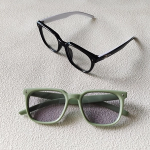 Detail of kids square sunglasses with star rivets in black and dusty green colors