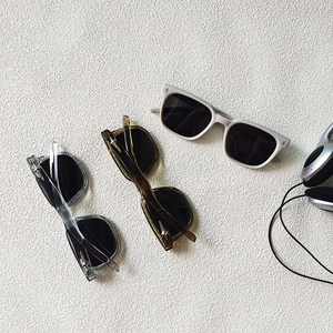 Close-up of square kids' sunglasses in three colors with silver star accents and headphones