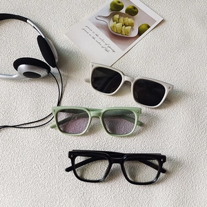 Close-up of kids square frame sunglasses with star detail in neutral and black tones