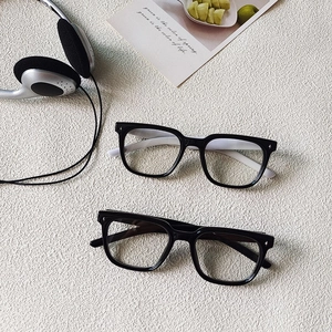 Detail of square kids sunglasses with black frames and tiny star-shaped metal rivets