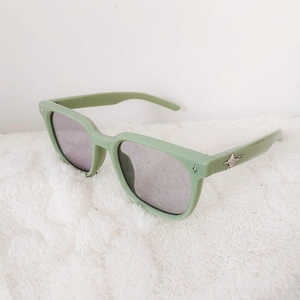 Detail of light green square sunglasses for kids featuring silver star decoration