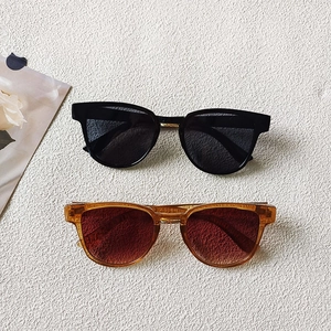 Detail view of black and amber tortoiseshell sunglasses with gradient lenses