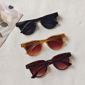 Flat lay of retro oversized sunglasses in black, amber, and tortoiseshell colors