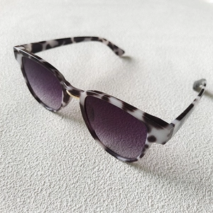 Close-up of marble pattern frame with purple gradient lenses and gold metal bridge