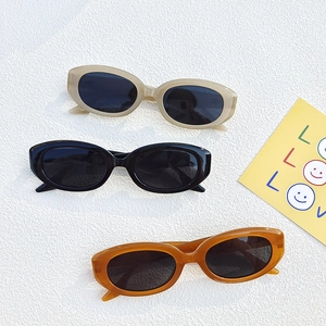 Trois paires de lunettes de soleil ovales vintage en kaki, noir et ambre sur blanc