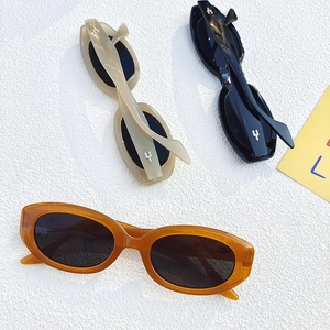 Lunettes de soleil ovales rétro en ambre, crème et noir avec accents métalliques