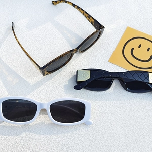 Trois lunettes de soleil tendance en écaille, noir et blanc sur fond texturé blanc
